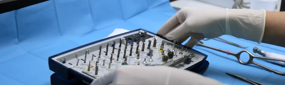 Dentista en Carabanchel colocando con precisión el material de implantología en la mesa de quirófano