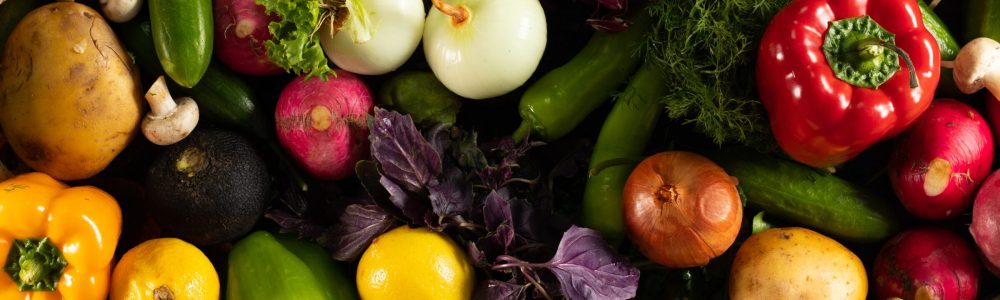 An overhead shot of different fresh vegetables put together on a black background